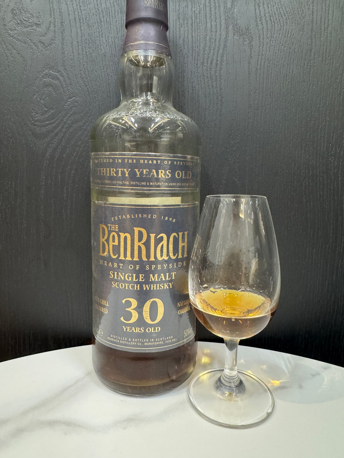 Illustrative image · Illustrative client photo: BenRiach 30 years, 50%, with glass; the reviewed 2006 bottling is unverified. Bottle top cut off in the original.