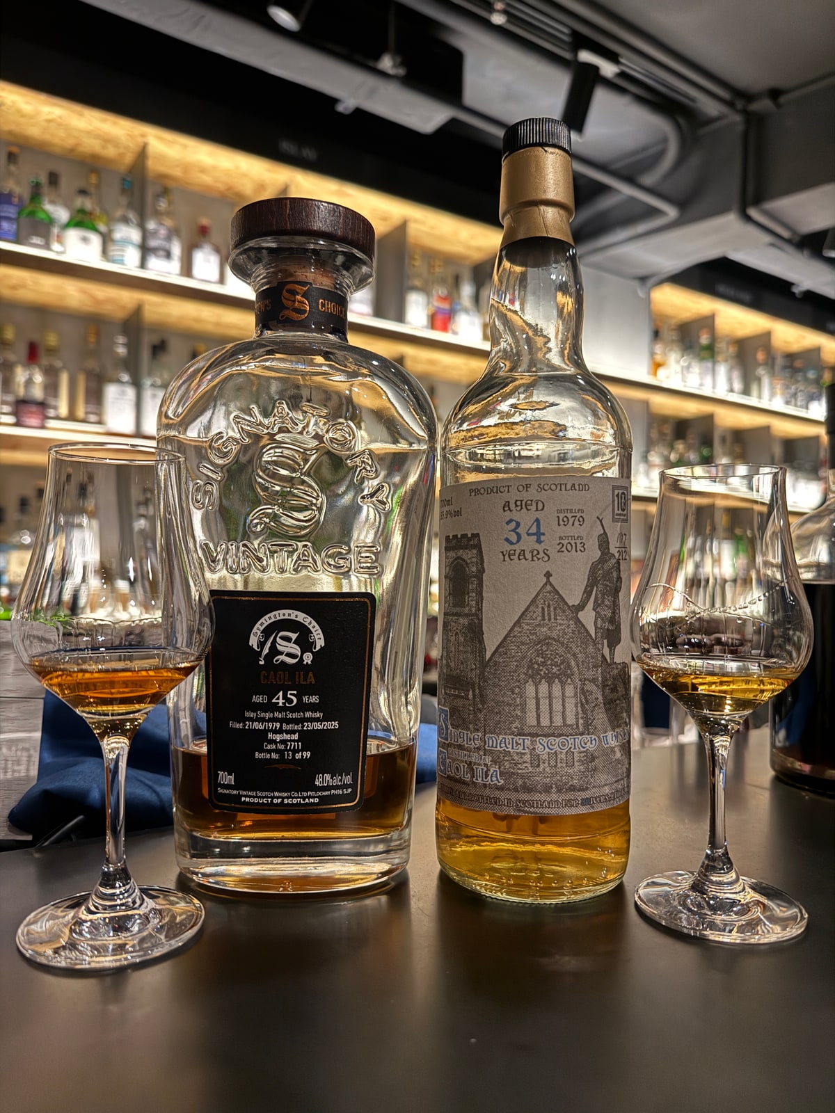 Illustrative image · Illustrative client photo: LEFT Signatory Vintage Caol Ila 1979/2025, 45 years, 48%, c7711; different release. Current Signatory title conflicts with the existing G&M link; right bottle and glasses retained.