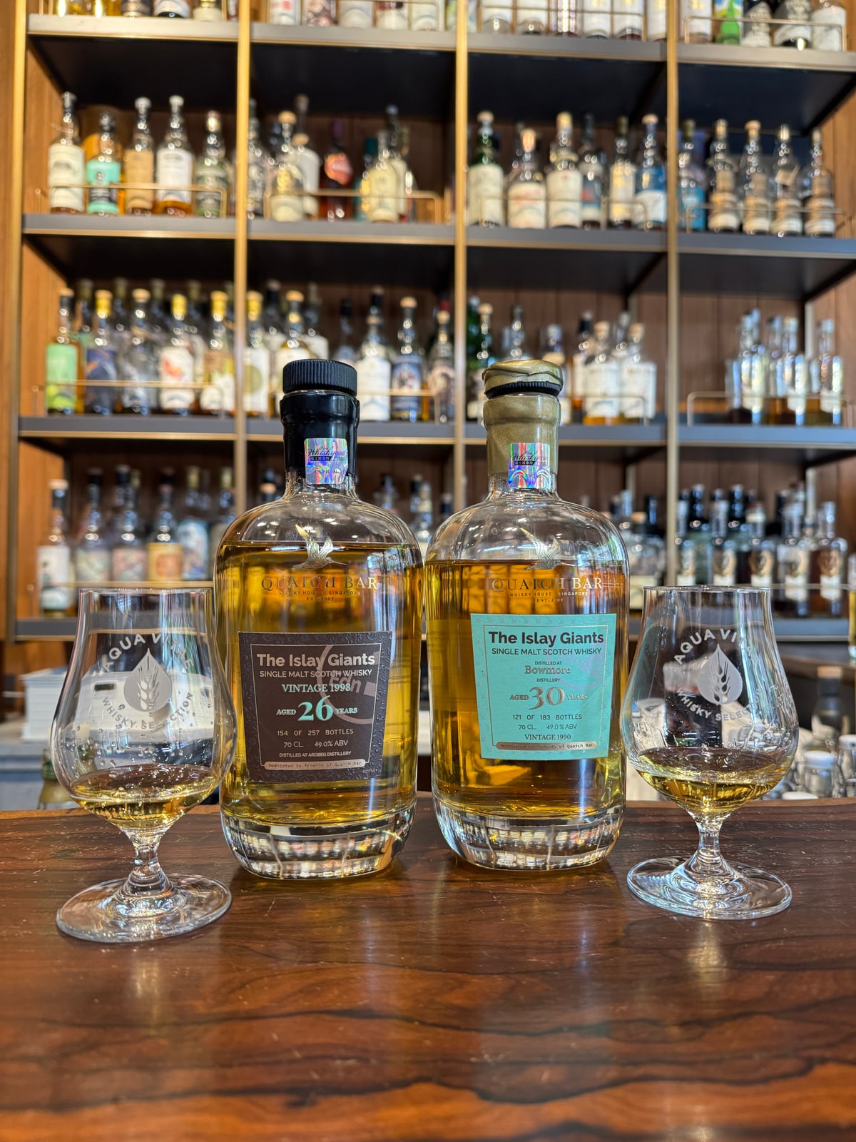 Client-supplied bottle photo of Quaich Bar Islay Giants Bowmore 30yo 1990 (right foreground bottle)