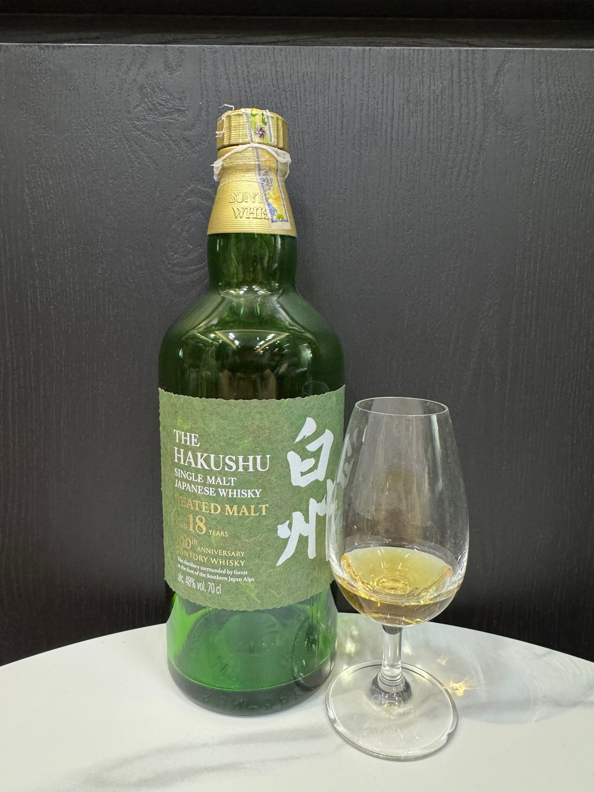 Client-supplied bottle photograph of Hakushu 18 Peated Malt, with the printed 100th anniversary label.