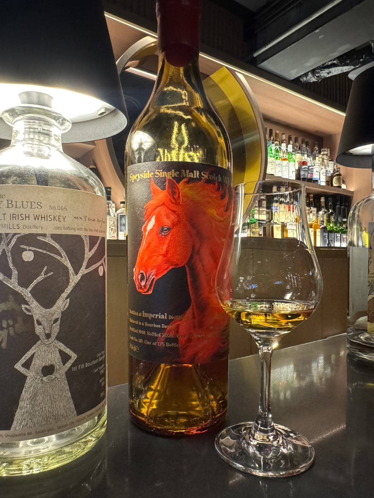 Illustrative image · Illustrative client photo: centre Imperial 1998/2025 horse-label bottle with glass; bottler/strength unverified; top clipped.