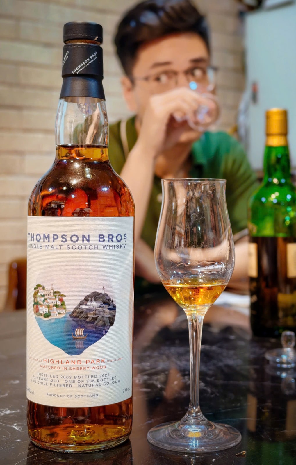 Client-supplied foreground bottle photo of Thompson Bros Highland Park 2003/2026 beside a tasting glass