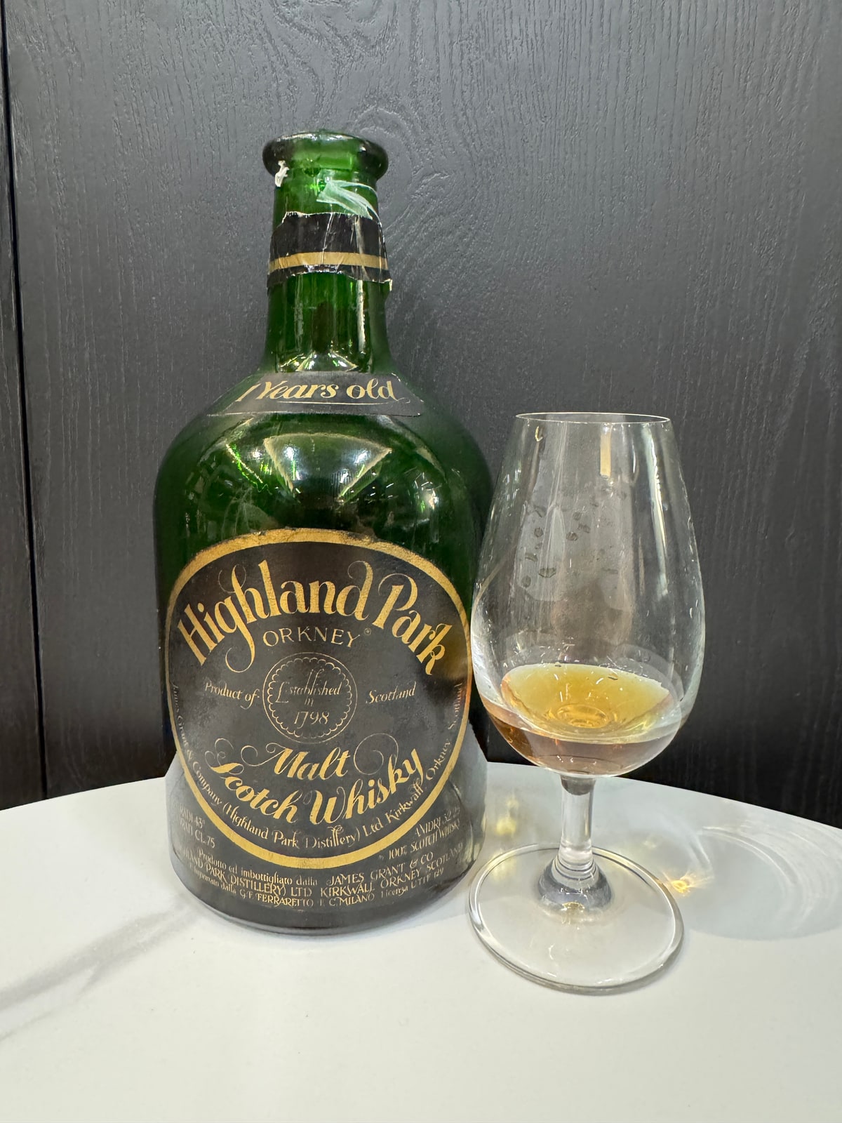 Illustrative image · Illustrative client photo: Highland Park 21, 43%, green dumpy bottle with Ferraretto label and glass. A different edition from the reviewed 1967/1991 release. Whole original frame.