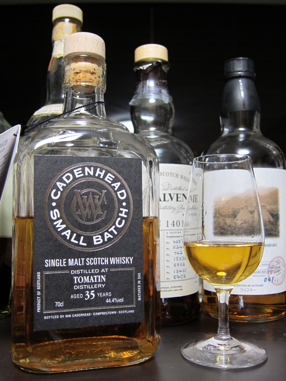 Internet critic photo, source くりりん: Cadenhead Small Batch Tomatin 35, 44.4%, with glass and background bottles. Critic identifies 1978/2014; these years are not printed on the visible front label. Full frame.