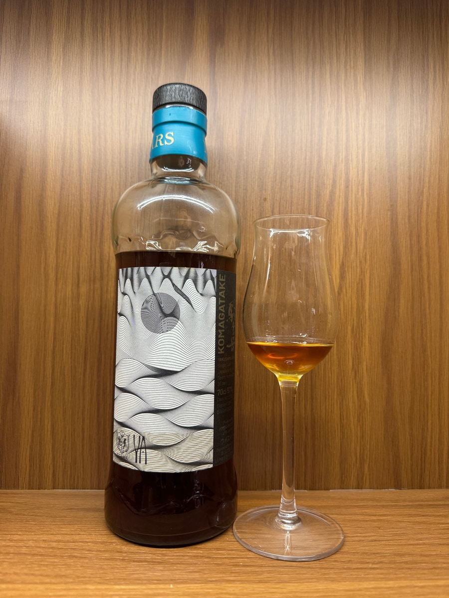Illustrative image · Illustrative — Client photo: Komagatake Yakushima bottle and glass; dates/c2122 not clearly visible.