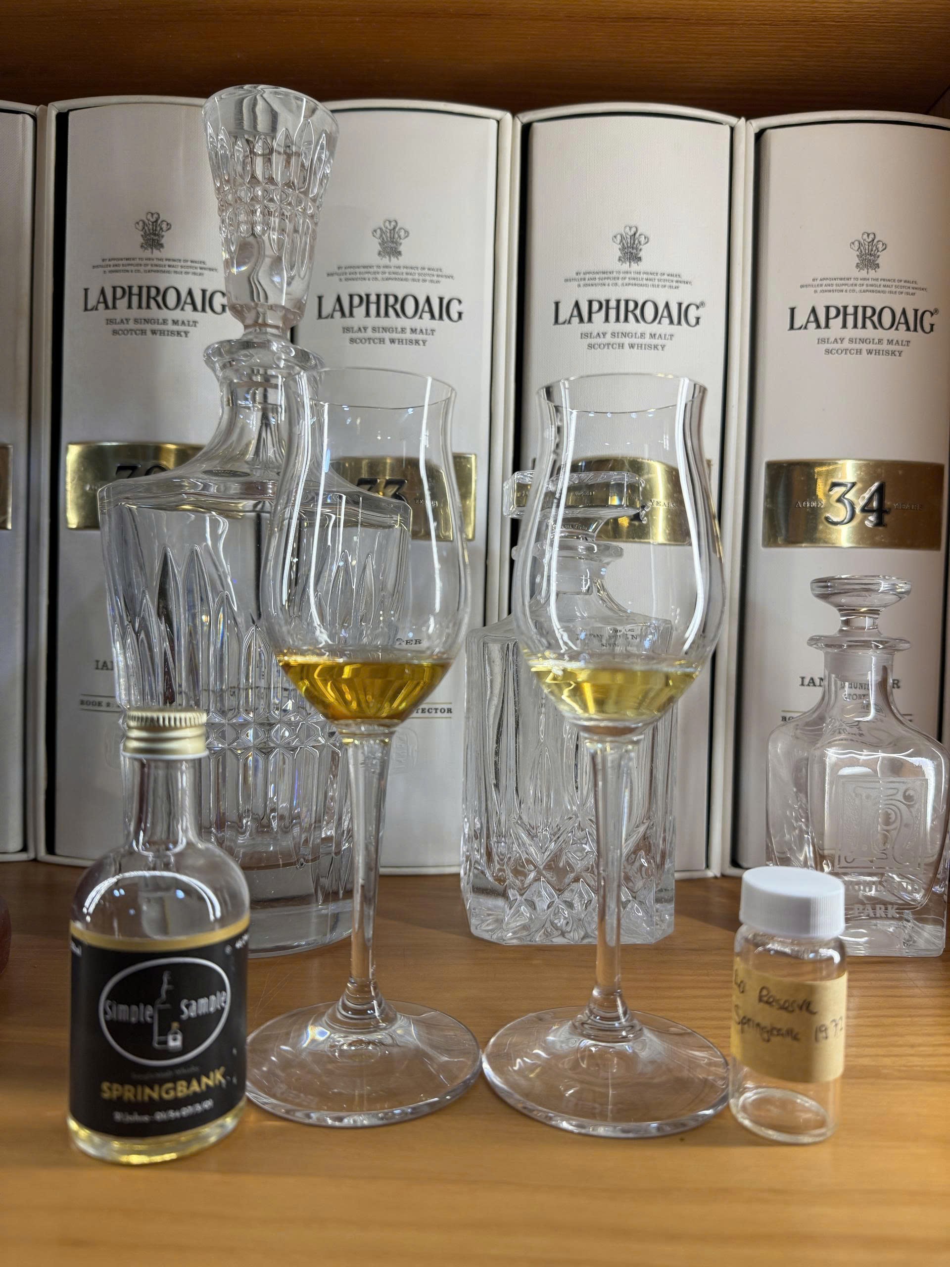 Client photo: Springbank tasting samples and glasses; Springbank 21 is the left sample; Laphroaig boxes behind.