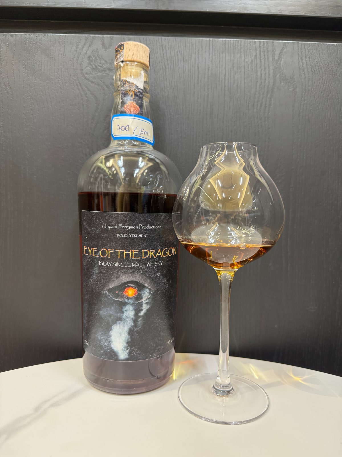 Client-supplied Eye of the Dragon bottle photograph beside a whisky glass; whisky from an undisclosed Islay distillery