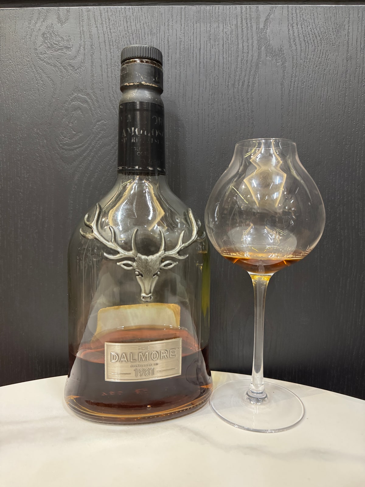 Illustrative image · Illustrative client photo: Dalmore decanter marked 1981 with glass. The reviewed 28-year-old, 44% edition is unverified.