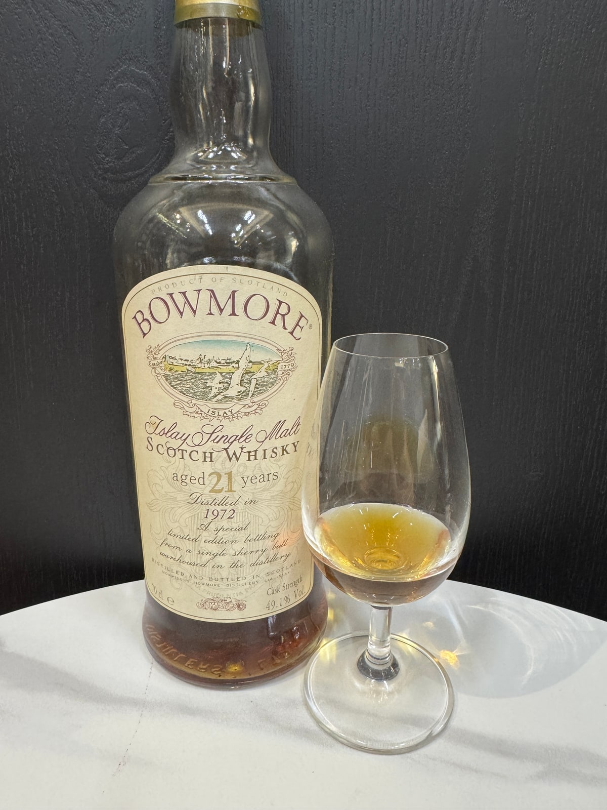 Client-supplied photo of the Bowmore 1972, 21-year-old, 49.1% foreground bottle beside a tasting glass